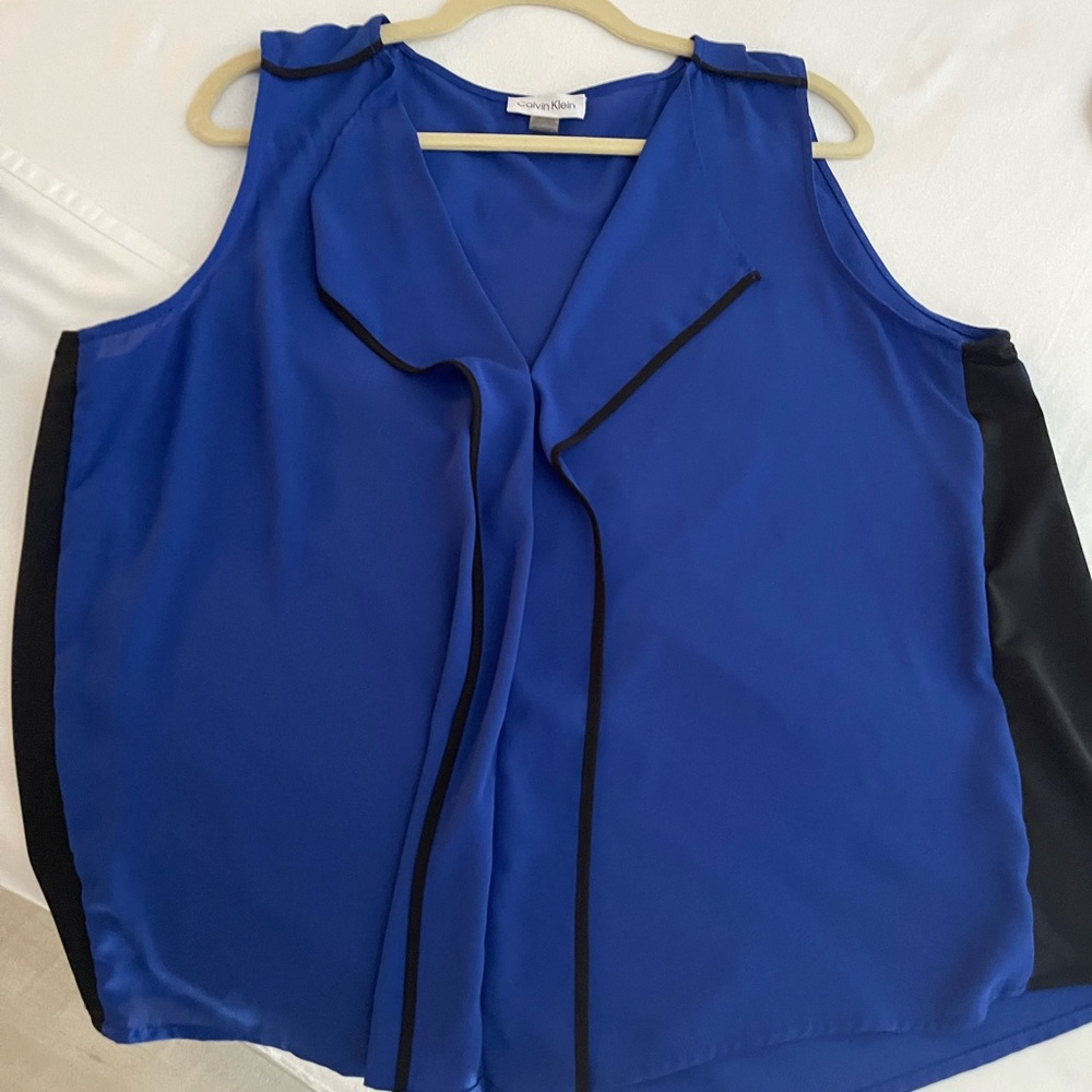 Blue button down sleeveless blouse with black trim detail